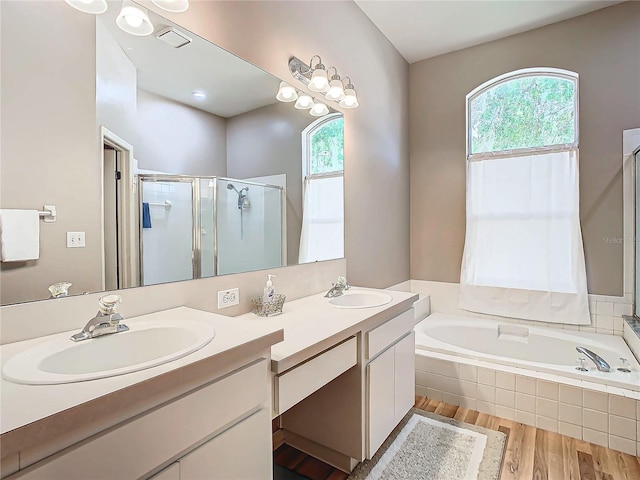 bathroom with plus walk in shower, vanity, and hardwood / wood-style flooring