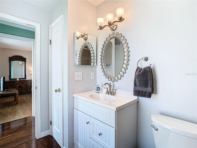 bathroom with hardwood / wood-style floors, vanity, and toilet