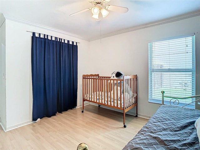 bedroom with light hardwood / wood-style floors, ceiling fan, and ornamental molding