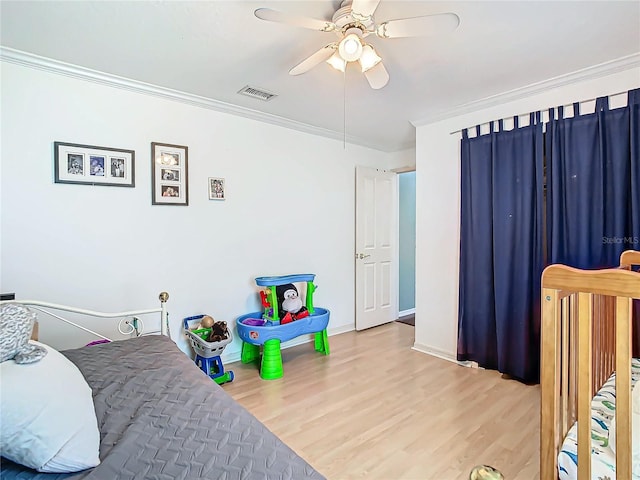 bedroom with ceiling fan, crown molding, and wood-type flooring