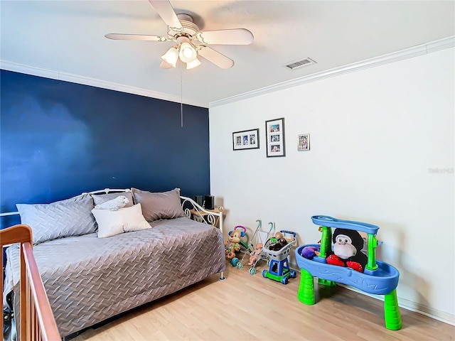 bedroom featuring ceiling fan, crown molding, and wood-type flooring