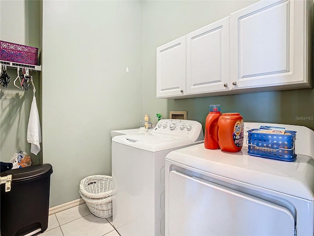 clothes washing area with cabinets, independent washer and dryer, sink, and light tile patterned floors