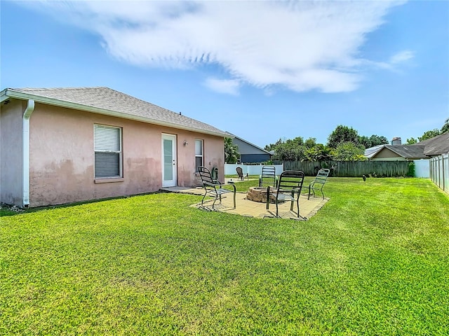 back of property with a patio area, a yard, and an outdoor fire pit