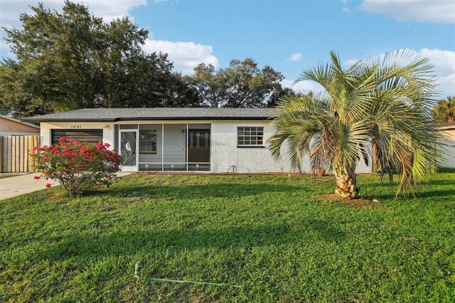 ranch-style house featuring a front yard and a garage