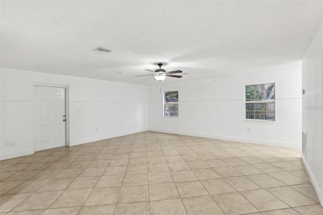 tiled spare room with ceiling fan and a textured ceiling