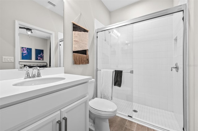 bathroom featuring vanity, toilet, and a shower with door