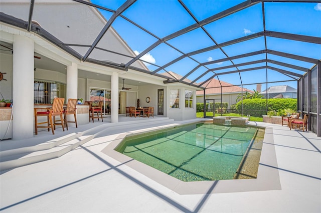 view of swimming pool with a lanai, a patio area, ceiling fan, and exterior bar