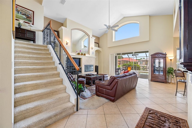 tiled living room featuring ceiling fan and high vaulted ceiling