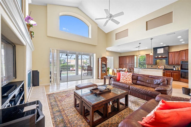 living room featuring ceiling fan, light tile patterned flooring, and high vaulted ceiling