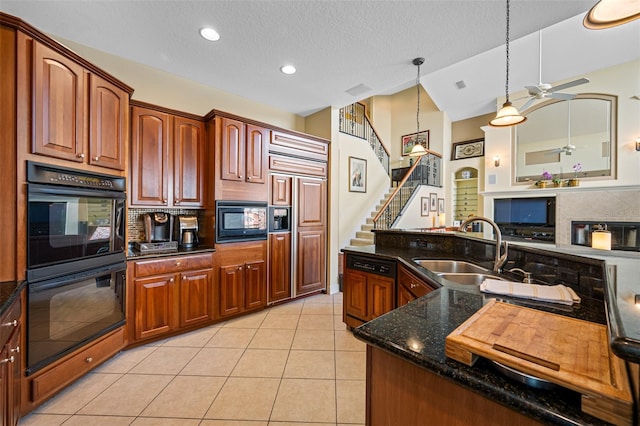 kitchen with dark stone counters, black appliances, sink, decorative light fixtures, and light tile patterned flooring