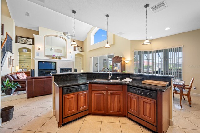 kitchen with dishwasher, sink, a kitchen island with sink, and decorative light fixtures