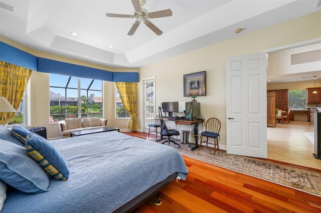 bedroom featuring hardwood / wood-style floors, a tray ceiling, and ceiling fan