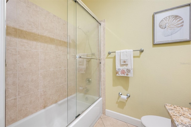 full bathroom with combined bath / shower with glass door, vanity, tile patterned floors, and toilet