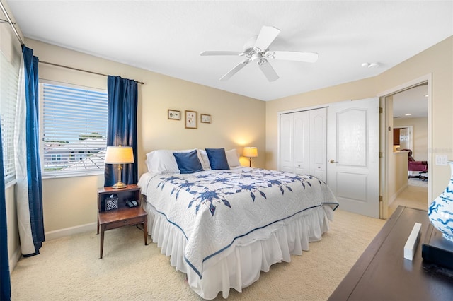 carpeted bedroom featuring ceiling fan and a closet