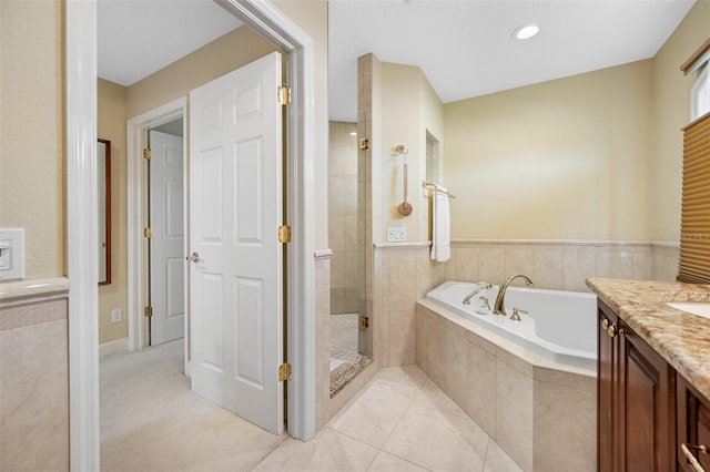 bathroom with tile patterned flooring, shower with separate bathtub, and vanity