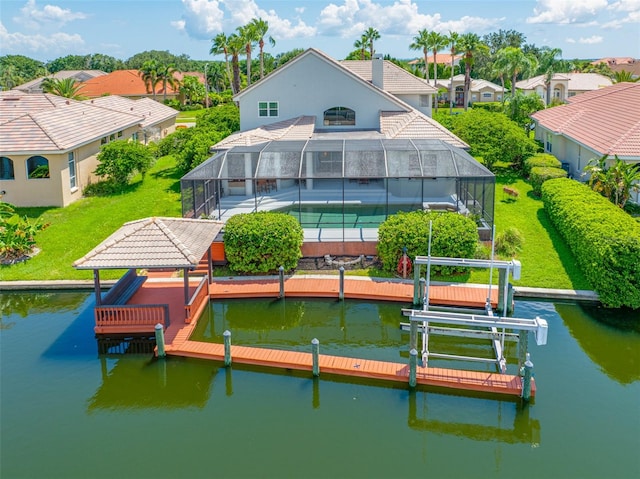 back of property with a lanai and a water view