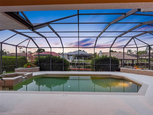 5510 E Longboat Blvd, Tampa, FL 33615 - pool at dusk with glass enclosure, a patio area, and a pool with connected hot tub