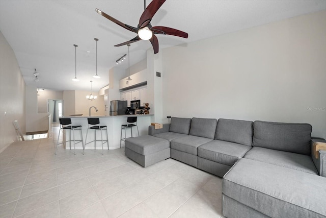 tiled living room with sink and ceiling fan with notable chandelier