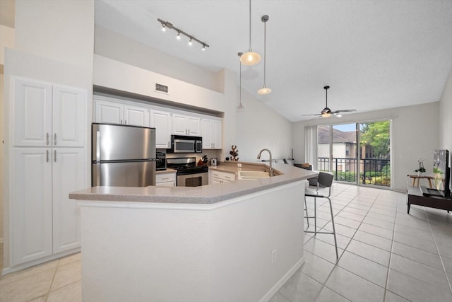 kitchen featuring ceiling fan, stainless steel appliances, hanging light fixtures, sink, and white cabinetry