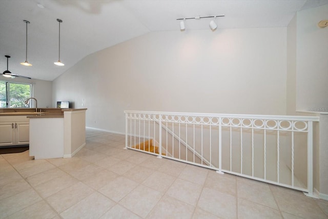 kitchen with rail lighting, ceiling fan, vaulted ceiling, and light tile floors