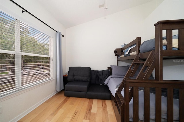 bedroom with vaulted ceiling and light wood-type flooring