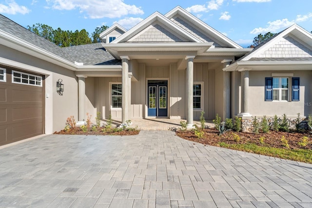 view of exterior entry featuring a porch and a garage