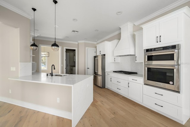 kitchen with white cabinetry, premium range hood, sink, and appliances with stainless steel finishes