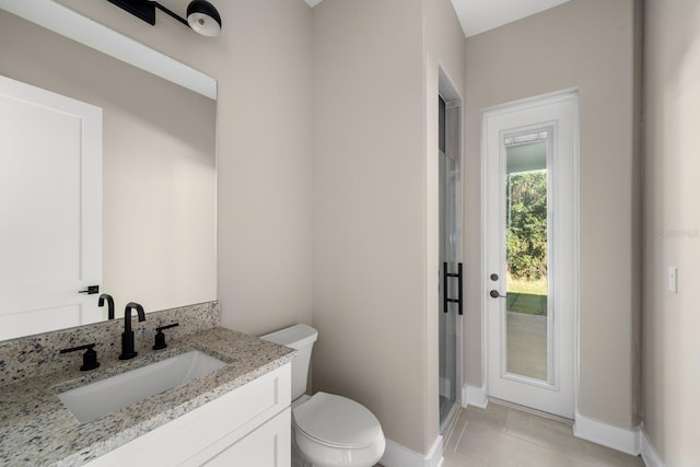 bathroom with tile patterned flooring, vanity, a shower with door, and toilet