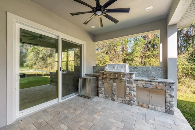 view of patio / terrace featuring a grill, ceiling fan, and an outdoor kitchen