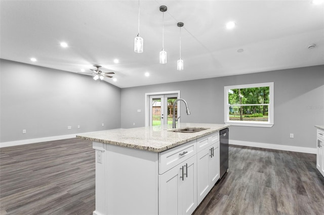 kitchen featuring french doors, sink, decorative light fixtures, a center island with sink, and white cabinets