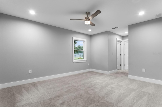 empty room with ceiling fan and light carpet