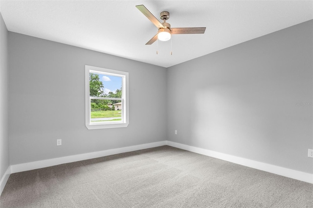 carpeted spare room featuring ceiling fan