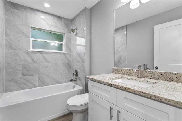 full bathroom featuring tiled shower / bath, vanity, toilet, and hardwood / wood-style floors