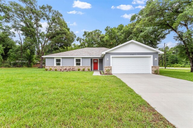 single story home with a garage and a front lawn