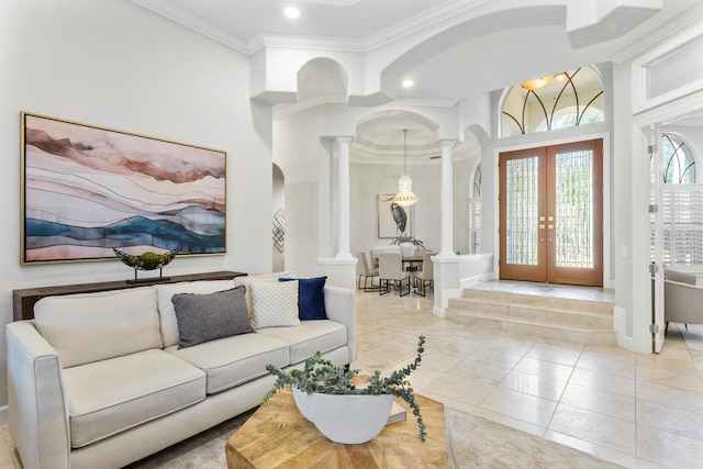 tiled living room featuring crown molding, french doors, and ornate columns