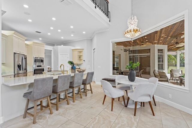 dining space featuring ornamental molding, a chandelier, and light tile patterned floors