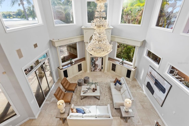 living room featuring a notable chandelier, a high ceiling, and light tile patterned floors