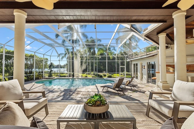 view of swimming pool featuring glass enclosure and a patio area