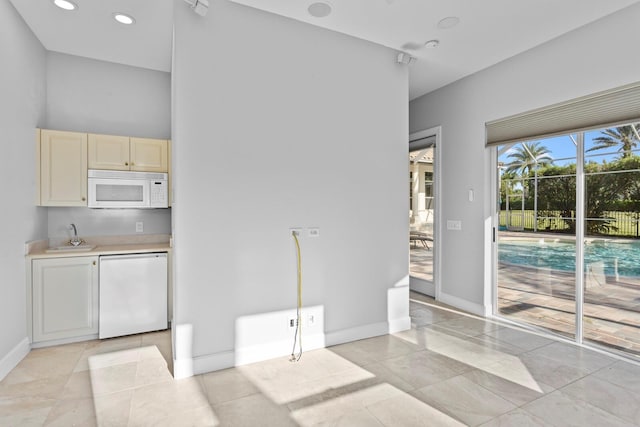 laundry area with light tile patterned floors and sink