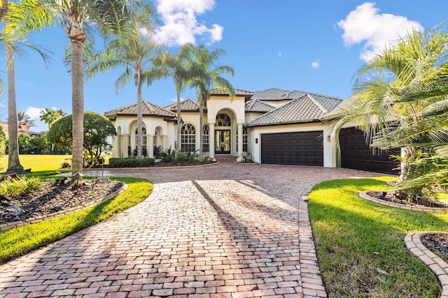 mediterranean / spanish home with a front lawn and a garage