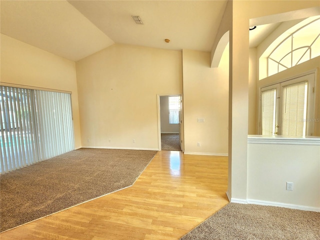 entrance foyer with high vaulted ceiling and light hardwood / wood-style flooring