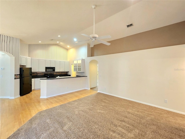 kitchen featuring backsplash, ceiling fan, black appliances, high vaulted ceiling, and white cabinets