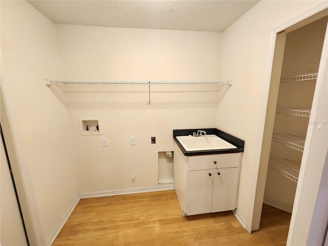 clothes washing area with hookup for a washing machine, gas dryer hookup, light hardwood / wood-style flooring, and electric dryer hookup