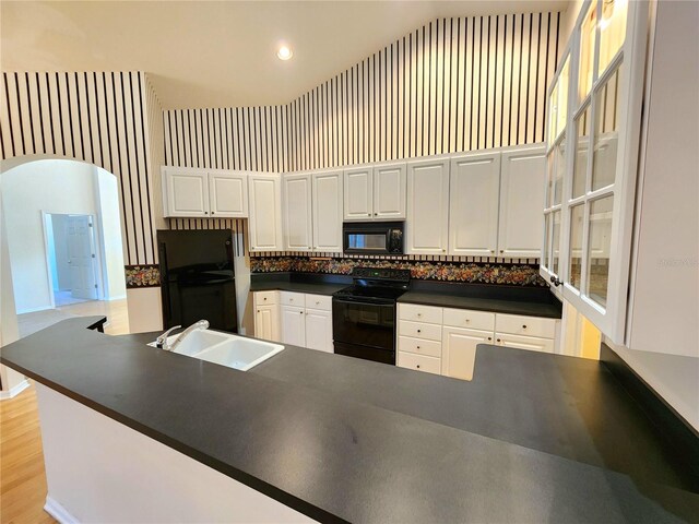 kitchen with white cabinetry, sink, tasteful backsplash, and black appliances