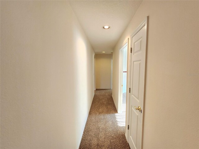 hallway with dark colored carpet