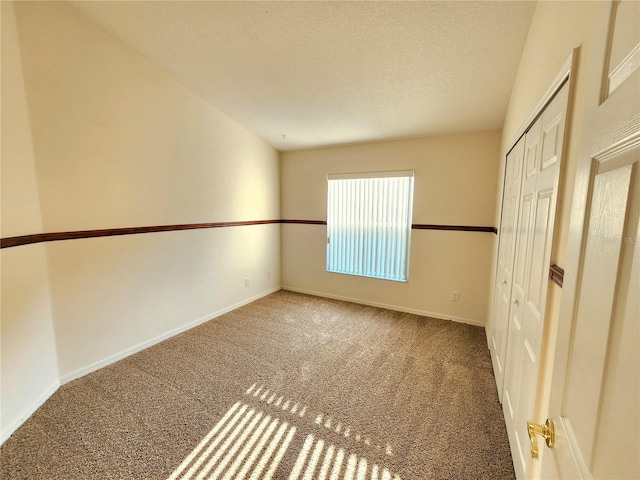 carpeted empty room with a textured ceiling