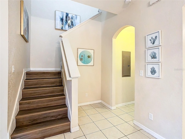 2705 Bushman Dr, Kissimmee, FL 34746 - staircase with electric panel, arched walkways, tile patterned floors, and baseboards