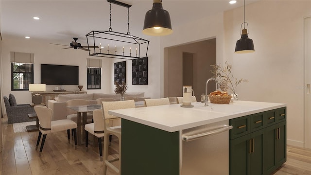 kitchen with green cabinets, a kitchen island with sink, dishwasher, hanging light fixtures, and sink