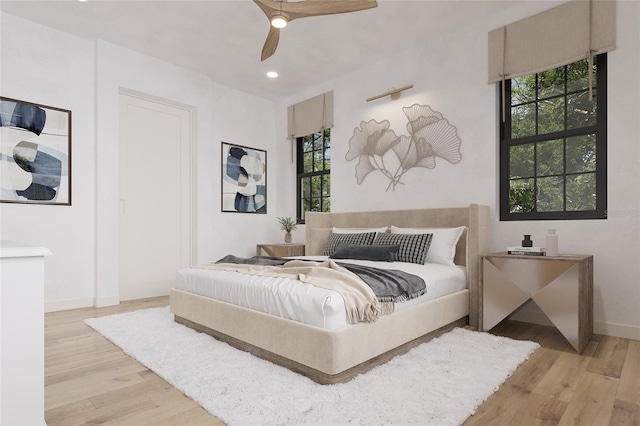 bedroom with ceiling fan and light hardwood / wood-style floors