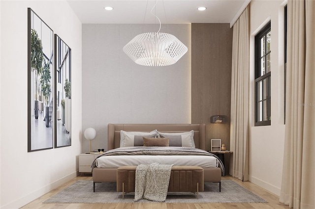 bedroom with light wood-type flooring and a notable chandelier